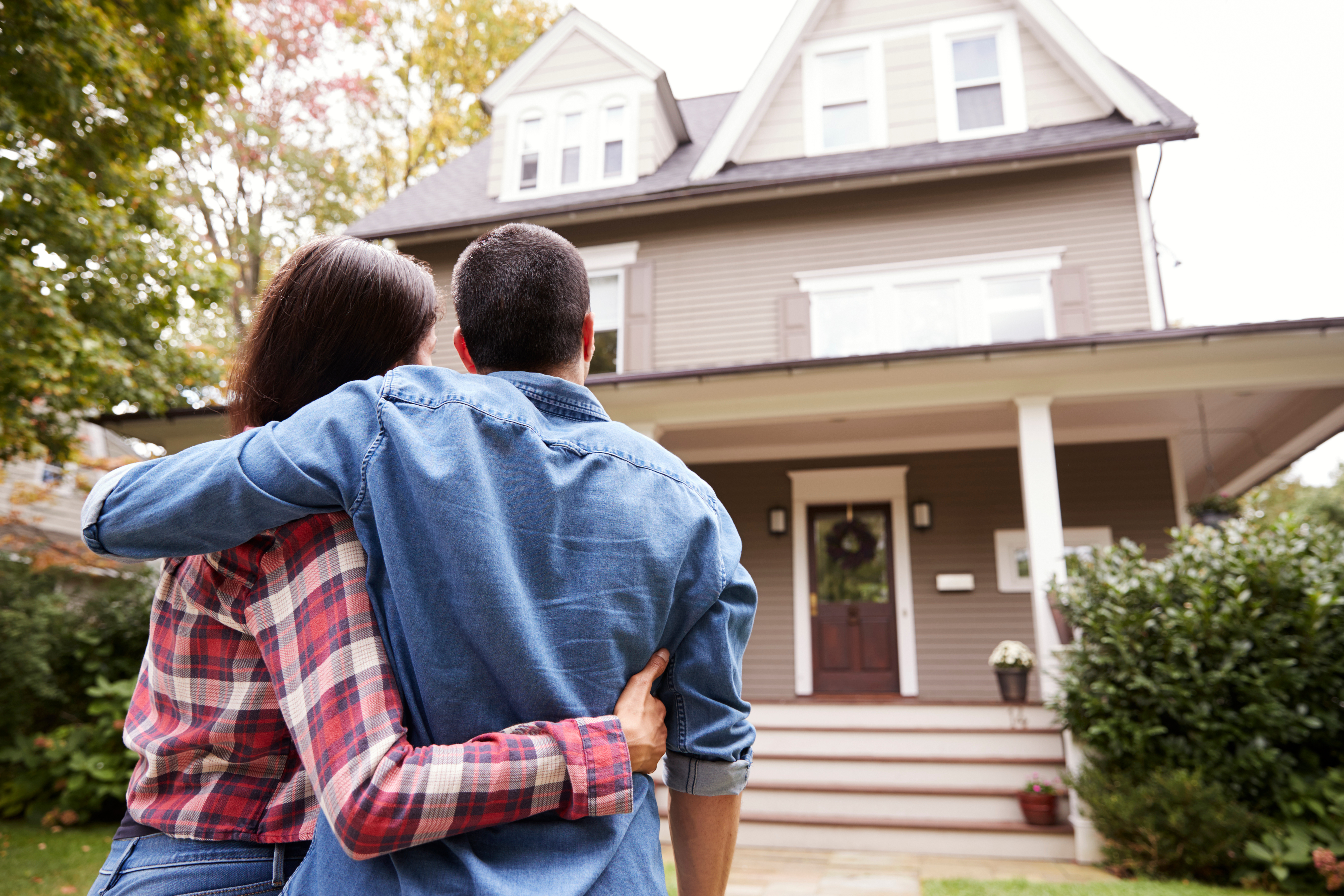 couple hug in front of house